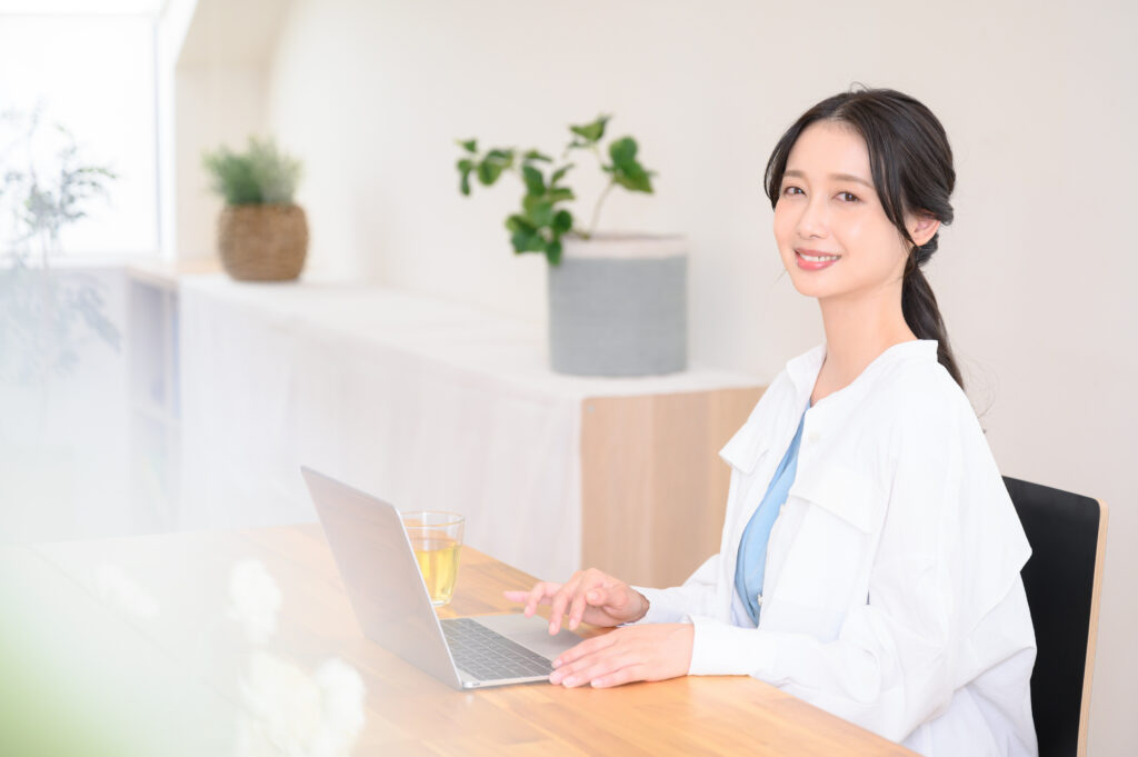 自宅でパソコンで仕事をしている笑顔の女性